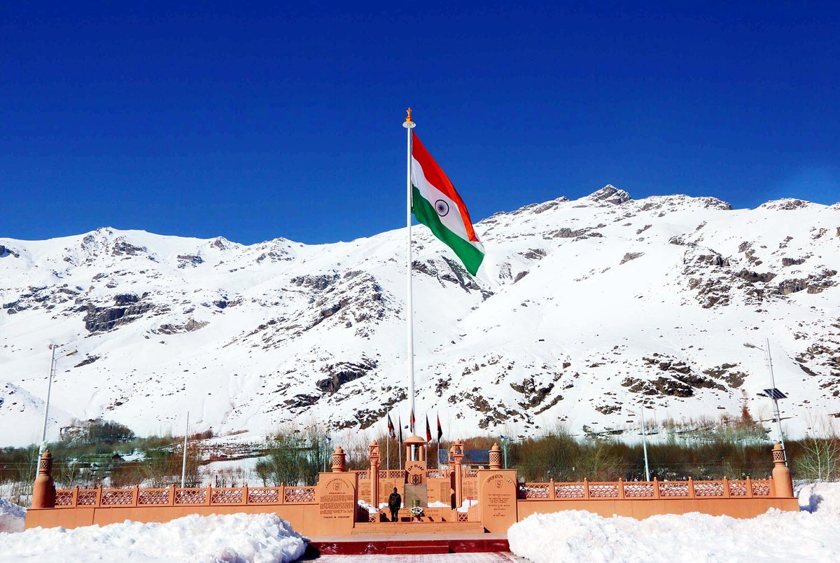 National flag at Kargil War Memorial, Dras, against snow-covered Himalayan peaks